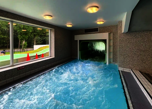 Der Wildwasserfluss endet in einem Becken im Innenbereich mit Fensterblick nach draußen.