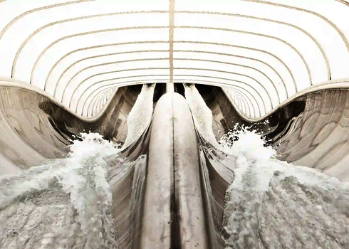 Wellenförmiger Verlauf der Raft Racer Reifenrutsche mit Wasserspritzern.