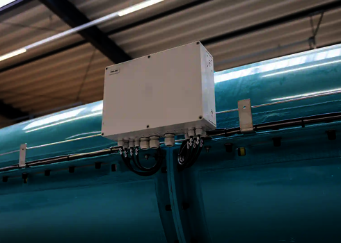 Steuerbox für LED-Lichteffekte auf einer türkisfarbenen Wasserrutsche unter Hallendach.