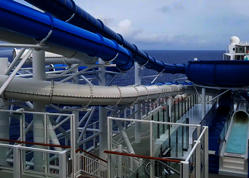 Zwei  Wasserrutschen auf dem Deck eines Kreuzfahrtschiffs mit Meerblick.