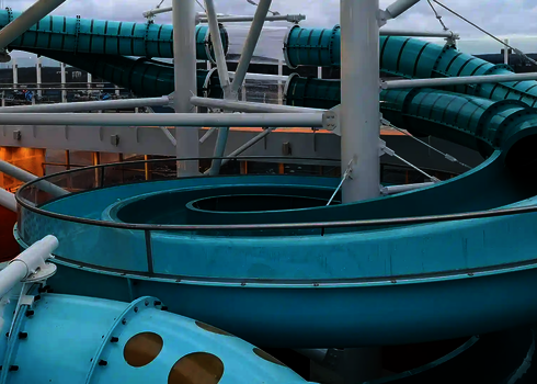 Spiralförmige 2-in-1 Racer Wasserrutsche mit transparenter Seitenbegrenzung auf einem Kreuzfahrtschiff.