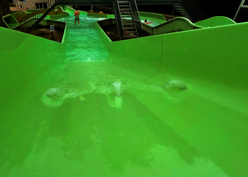 Blick von oben eines Wildwasserflusses auf en Becken, in dem sich ein Mann befindet.