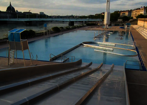 Multilane im Freibad mündet direkt ins Schwimmbecken neben einem Badeaufsichtsturm.