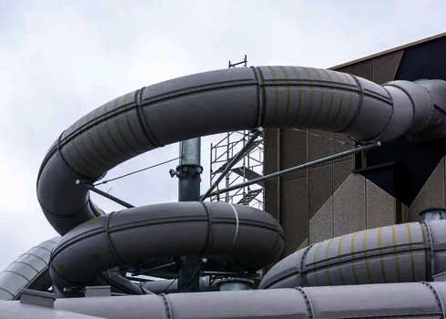 Eine weiße RR1200 Wasserrutsche mit Streichen und Punkten, außerhalb eines Gebäudes.