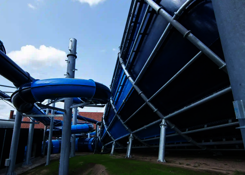 Blick unter den Cyclone und die blaue Röhrenrutsche mit Stahlkonstruktion auf Wiese.