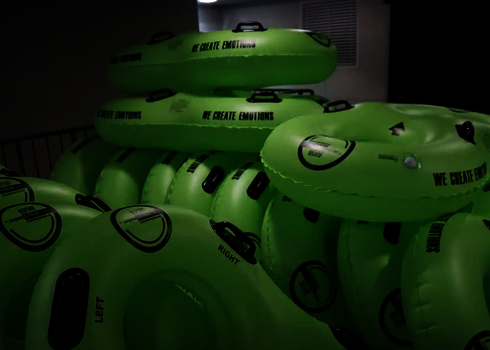 Mehrere grüne Rutschreifen mit Griffen sind in einem Lagerbereich gestapelt.