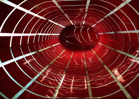 Eine rote Wasserrutsche von innen, mit karierten Tageslichteffekten.