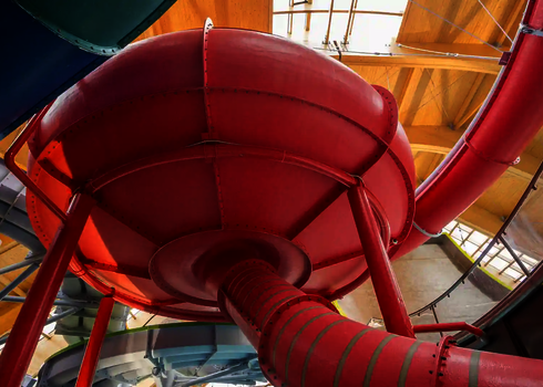 Untenansicht auf ein rote Body Bowl, die von weiteren Wasserrutschen umgeben ist.