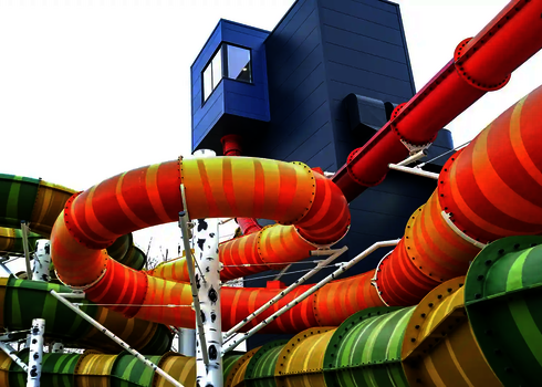 Bunte Wasserrutchen unter freiem Himmel, mit U-Drop aus einem Gebäude.