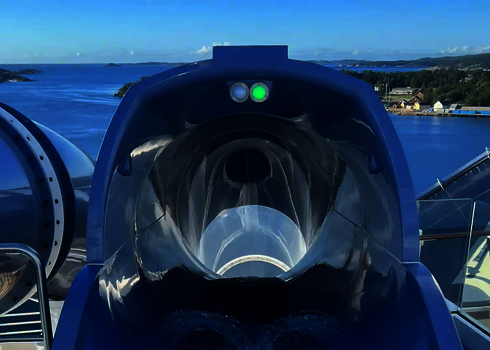 Einstiegsbereich mit Sensorampel der blauen Lotus Reifenrutsche mit Meerblick auf einem Kreuzfahrtschiff.