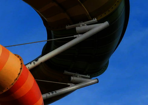 Detailansicht der Halterungen der bunten Family Twister Wasserrutschen vor blauem Himmel.