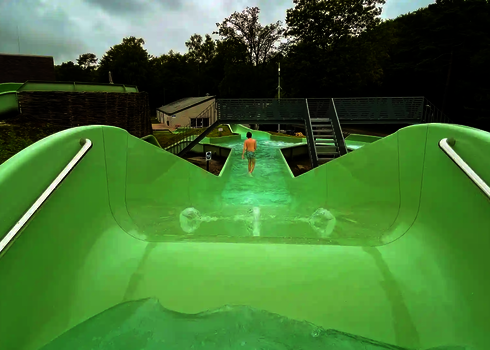 Ansicht von oben auf eine Person, die sich in einem grünen Wildwasserfluss befindet.