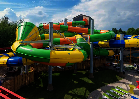 Bunte Crazy Cone Reifenrutsche mit mehreren Röhrenelementen in einem Freizeitbad bei Sonnenschein.