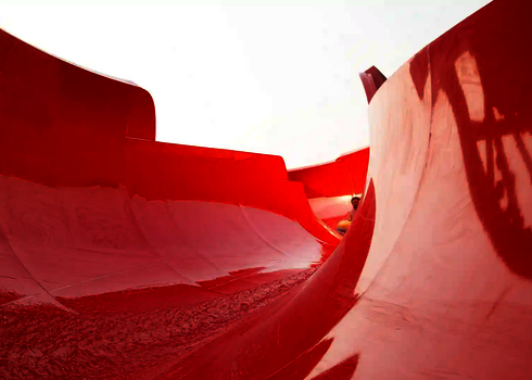 Innenansicht einer roten Wasserrutsche mit leichtem Wasserlauf.