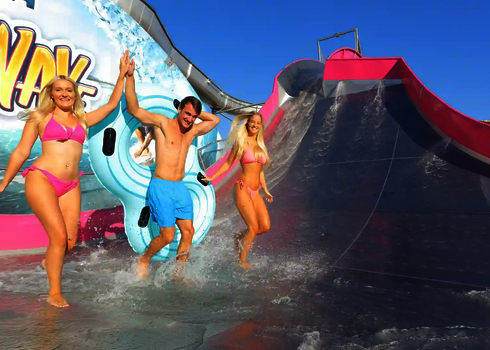 Drei junge Erwachsene laufen lachend von der Sidewinder Wasserrutsche.