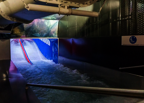  Auslaufbereich der Raft Racer Reifenrutsche mit Wasserbecken und Sicherheitsgeländer.