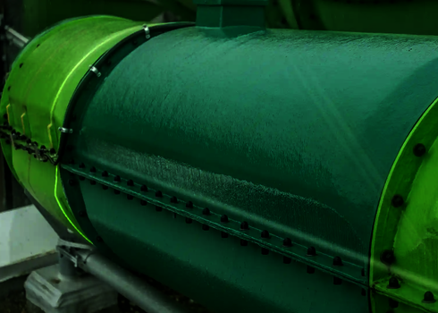 Nahaufnahme einer grünen Wasserrutsche mit sichtbaren Schraubverbindungen.