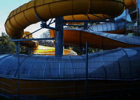 Gelbe Crazy River Wasserrutsche außerhalb eines Gebäudes.