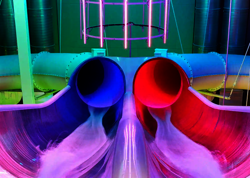 Zwei nebeneinander liegende Rutschen mit LED-Lichteffekten am Auslaufbereich.