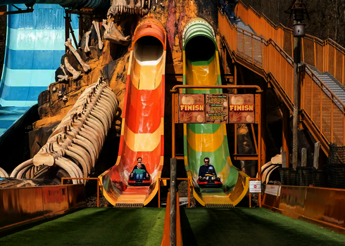 Freizeitpark mit zwei Harakiri Wasserrutschen auf denen sich Personen befinden.