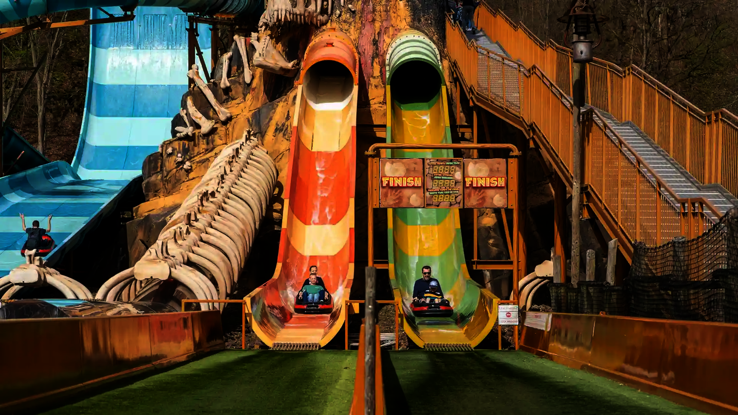 Freizeitpark mit zwei Harakiri Wasserrutschen auf denen sich Personen befinden.