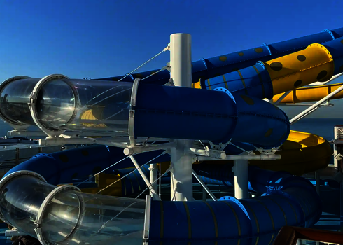 Eine blau gelbe RR1200 Wasserrutsche mit transparenten Acryl-Abschnitten auf einem Kreuzfahrtschiff.