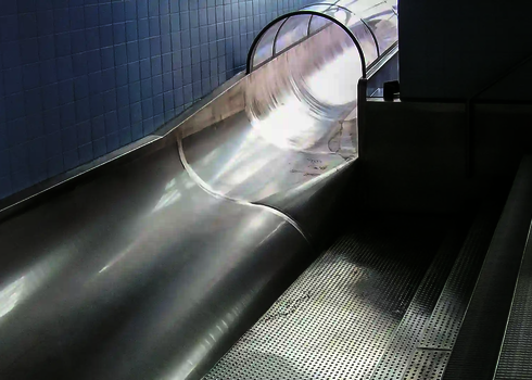 Run-outs of a stainless steel slide with protected tunnel and staircase with handrail.