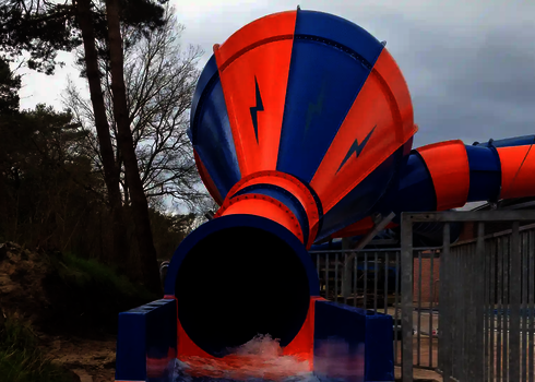 Frontaler Blick auf Crazy Cone mit orange-blauer Farbgebung und Wasser am Auslauf.