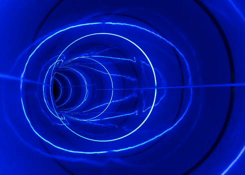 Blaue LED-Ringe erzeugen helle Lichtmuster in einer Röhrenrutsche.