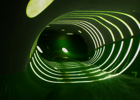 Innenaufnahme der Family Twister Wasserrutsche mit grünen Wänden und LED-Beleuchtung.