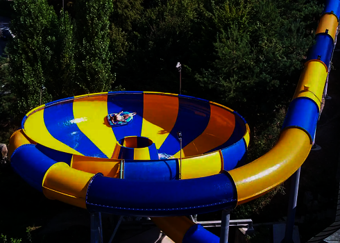Raft Bowl mit rutschender Person, umgeben von Bäumen.
