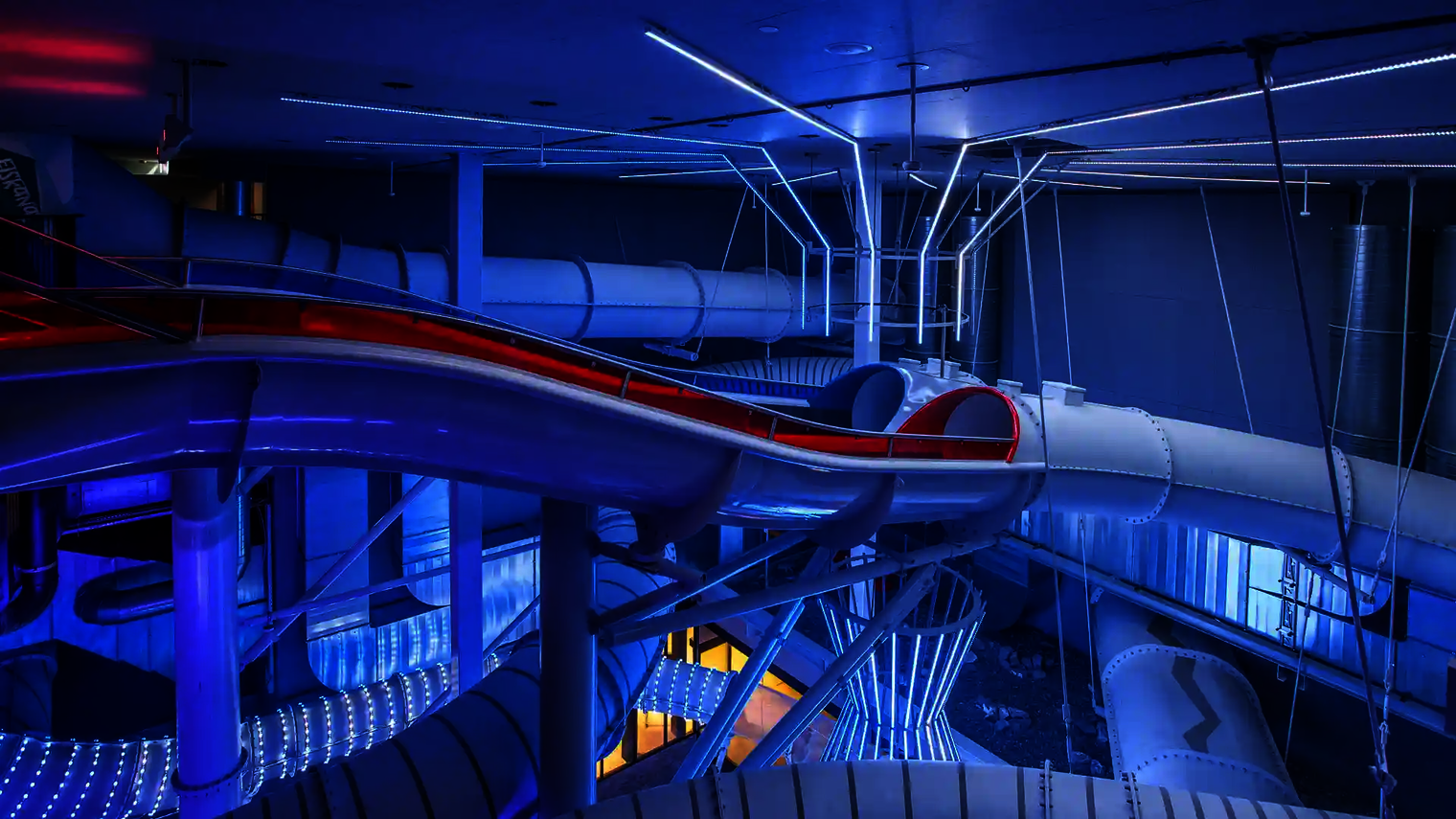 Blau beleuchtete Startplattform der Raft Racer Doppelrutsche mit Lichtinstallationen.