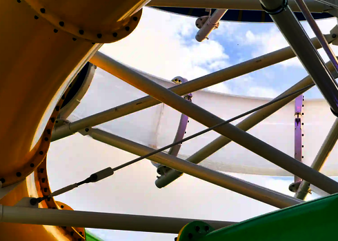 Gelbe, grüne und blaue Rutschen der RR900 zwischen Trägern und Seilen aufgenommen.