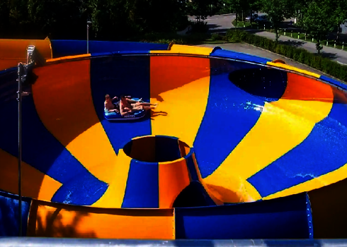 Zwei Personen sitzen hintereinander in Raft Bowl mit knalligen Farben.