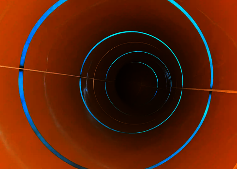 Innenansicht einer Röhrenrutsche mit blauen Lichteffekten.