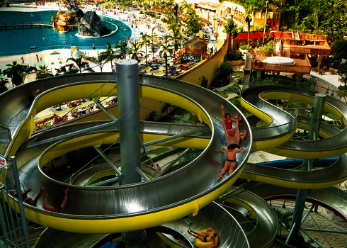 Mehrspurige Edelstahl-Wasserrutsche WR1040 in einem tropischen Indoor-Wasserpark, von oben fotografiert.