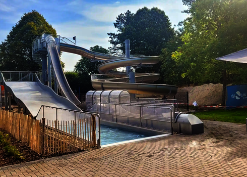 Ein Freifall, eine Breitwellenrutsche und eine WR1040 aus Edelstahl in einem Freibad.