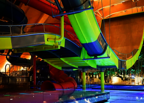 Unterschiedliche Typen bunter Wasserrutschen in einem Hallenbad.