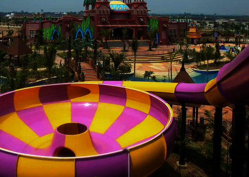 Wasserpark mit schlossähnlichem Gebäude und gelb-pinken Raft Bowl.