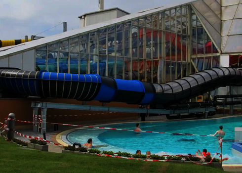 Der Speed Blaster führt durch ein Freibad, Badegäste sind im Wasserbecken zu sehen.