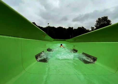 Eine Person wird von der Strömung durch den offenen Wildwasserfluss getragen.