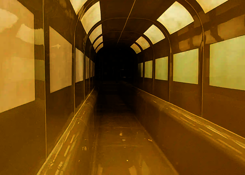 Interior view of a covered water slide with yellow sides and light panels.