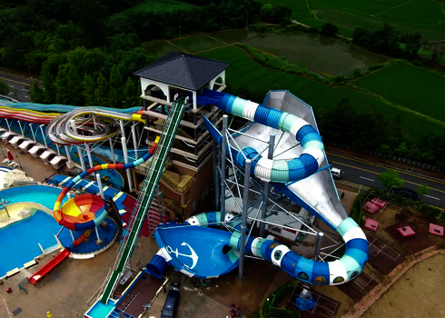 Large water park with several slides and a clearly visible green raft conveyor in the center.