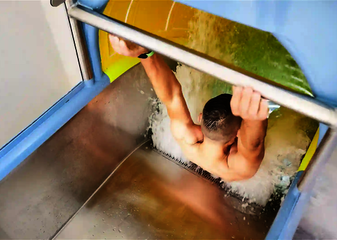 Eine Person hält sich im Startbereich einer Fallstart Wasserrutsche an einem Sicherheitsbügel fest, bereit zu rutschen.