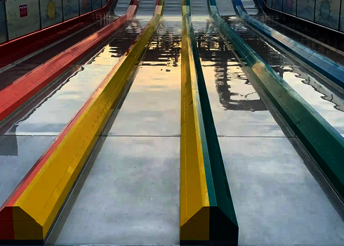 Leere bunte Matracer Rutschenbahnen glänzen im Sonnenlicht.