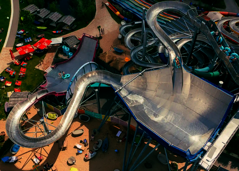 Bunter Außenbereich des Galaxy Erding Wasserpark mit verschlungenen Rutschenanlagen. 