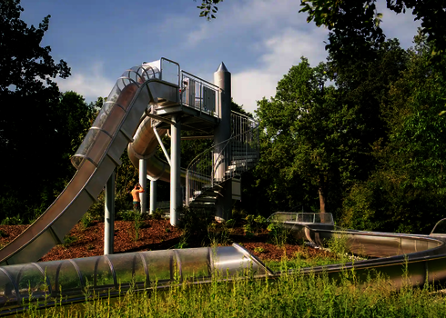 Freifallrutsche im Grünen mit Startturm und Auslauf.