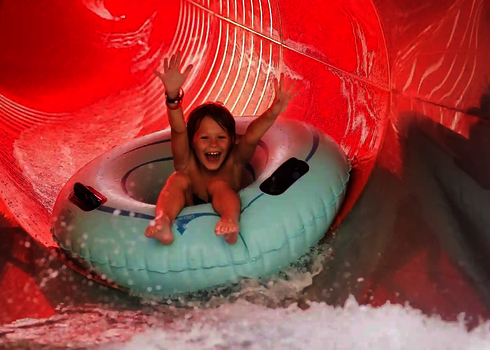 Kind rutscht lachend im Rutschreifen eine rote RR1400 Wasserrutsche.