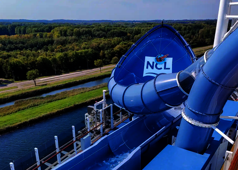 Blaue Lotus Wasserrutsche mit NCL-Logo auf einem Kreuzfahrtschiff.