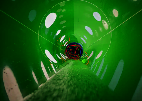 Eine grüne Wasserrutsche von innen mit gepunkteten Lichteffekten.